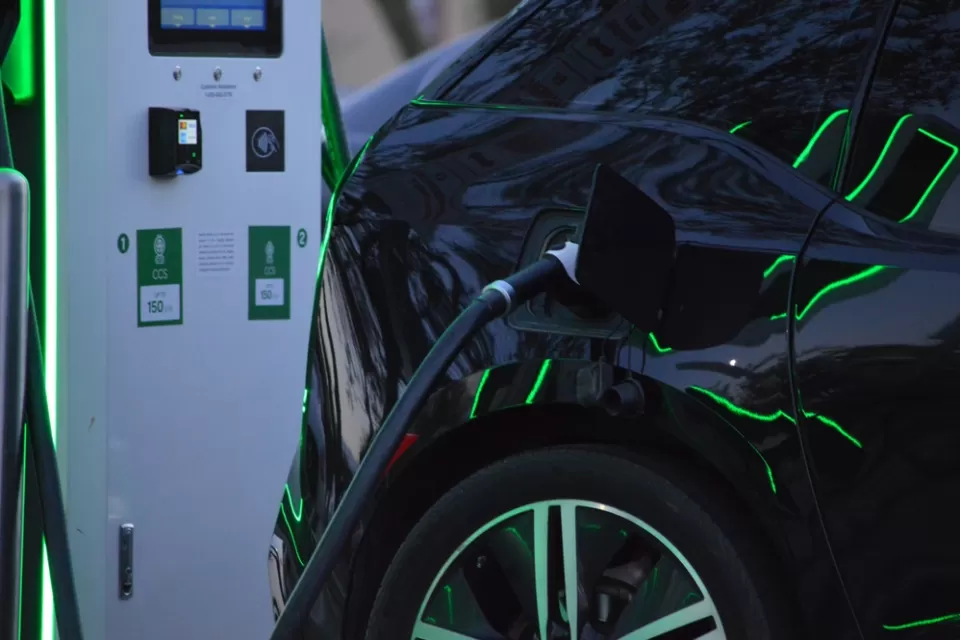 Close-up of black electric car charging at station